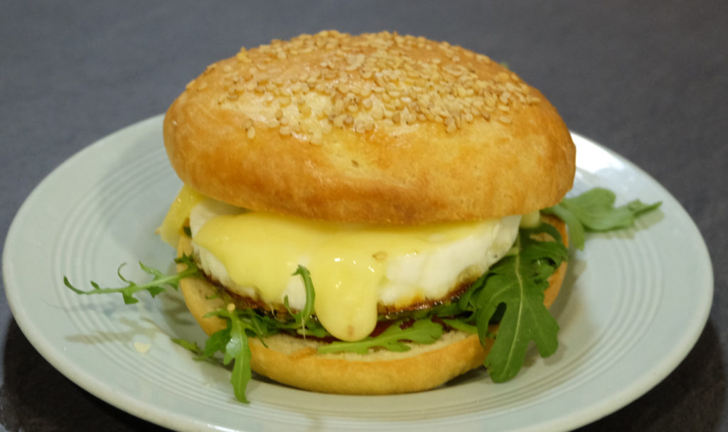 A bun with rocket, red onion chutney, fired egg and cheddar