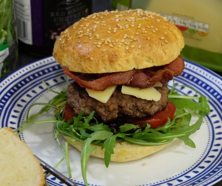 Burger z rukolą, chutney z czerwonej cebuli, cheddarem i boczkiem